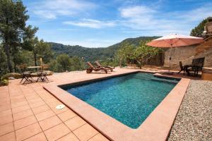 a swimming pool with a table and chairs and an umbrella at Nature & Tranquility only 25km from Barcelona in Torrelles de Llobregat