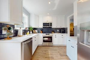 a kitchen with white cabinets and stainless steel appliances at Game Day Hub < 1 Mi to Stadium & Patriot Place! in Foxborough