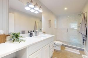 a white bathroom with a sink and a toilet at Game Day Hub < 1 Mi to Stadium & Patriot Place! in Foxborough +16 photos