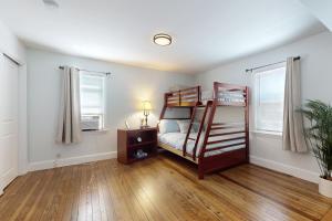a bedroom with a bunk bed and a wooden floor at Game Day Hub < 1 Mi to Stadium & Patriot Place! in Foxborough