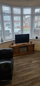 a living room with a flat screen tv on a table at Sandringham House in Stockton-on-Tees