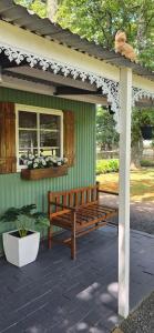 a wooden bench under a gazebo on a patio at Little Tin House in Van Reenen