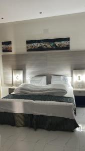 a bedroom with a large bed with two lights at فندق ثرا الرواد in Abu Arish