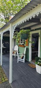 a pergola with two chairs and a table on a patio at Little Tin House in Van Reenen