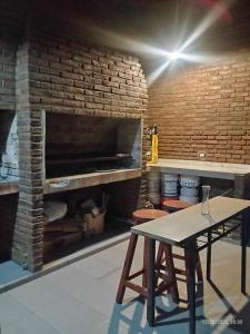 a room with a brick fireplace and a table at Ye muá, ye tuá in City Bell