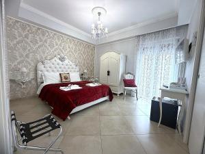 a bedroom with a red bed and a chandelier at Olympus Pompei Ruins in Pompei