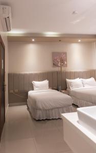 two beds in a room with white walls at Ceibo Real in Portoviejo +72 photos