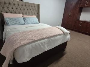 a bedroom with a large bed with a large headboard at Maglovir Plumstead 5 rooms bulk in Plumstead