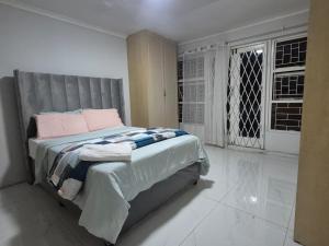 a bedroom with a large bed with pink pillows at Maglovir Plumstead 5 rooms bulk in Plumstead