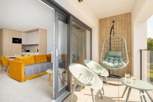 a living room with a couch and chairs and a swing at Apartamenty Łukęcin Joy me 3 in Łukęcin