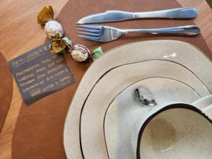 a table with a plate and a fork and a spoon at Loft próximo à Oktoberfest Blumenau in Blumenau
