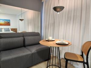a living room with a couch and a table at Loft próximo à Oktoberfest Blumenau in Blumenau