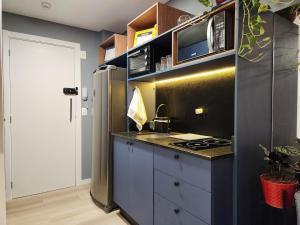 a kitchen with a stove and a refrigerator at Loft próximo à Oktoberfest Blumenau in Blumenau +39 photos
