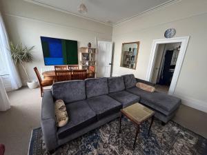 a living room with a blue couch and a table at Anns Sea View Suite in Cobh +12 photos