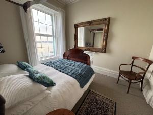 a bedroom with a bed and a mirror and a chair at Anns Sea View Suite in Cobh