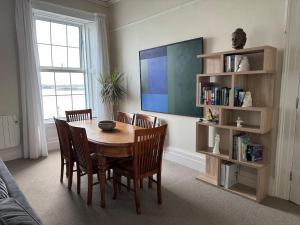 a dining room with a table and chairs and a tv at Anns Sea View Suite in Cobh