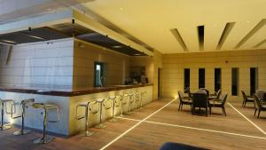 a restaurant with a bar and tables and chairs at Baghdad Do Hotel in Baghdād