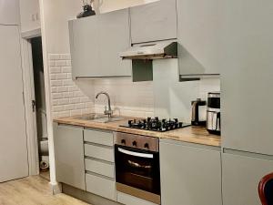 a kitchen with white cabinets and a stove top oven at Studio in Edgware