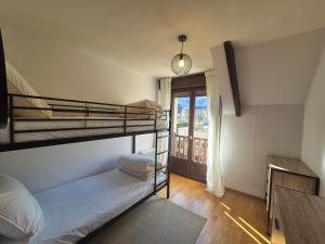 a bedroom with two bunk beds and a window at Le nid des Pyrénées in Vielle-Aure