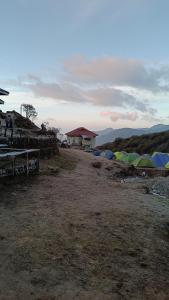 a group of tents are lined up in a field at Kedar cloud camp in Kedārnāth