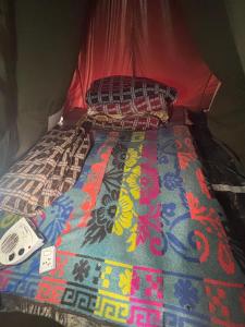 a bed in a tent with a comforter on it at Kedar cloud camp in Kedārnāth