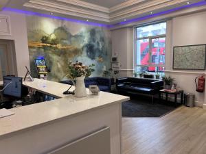 a living room with a couch and a table with flowers at Lidos Hotel in London