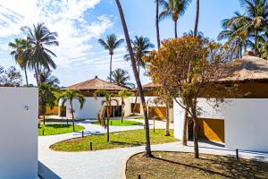 a courtyard with palm trees and a building at Palm Beach Resort in Serekunda