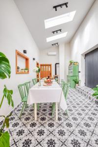 ein Esszimmer mit einem weißen Tisch und grünen Stühlen in der Unterkunft Sobe Rafut in Nova Gorica