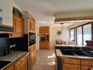 a kitchen with wooden cabinets and a counter top at Le nid des Pyrénées in Vielle-Aure