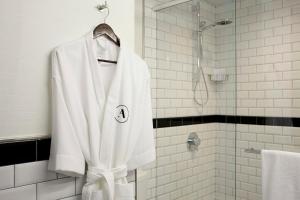 a white robe is hanging in a bathroom at Archer Hotel New York in New York +75 photos
