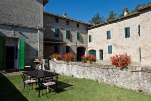 a table and chairs in a yard next to a building at B&B Cortebonomini apartment in Neviano degli Arduini