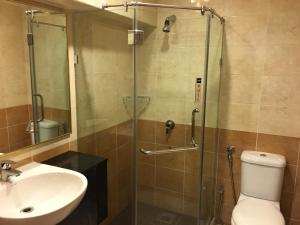 a bathroom with a shower with a toilet and a sink at Lintas Plaza Hotel in Kota Kinabalu