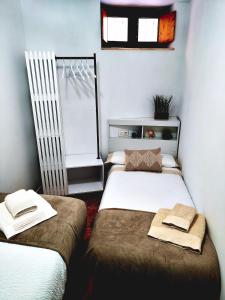 a room with two beds and a window in it at La casa de Tentenecio in Salamanca