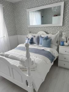 a white bed in a bedroom with a mirror at Dernvale House -Double Room sleeps 2 in Mullinderg