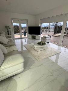 a white living room with a television and a couch at Dernvale House -Double Room sleeps 2 in Mullinderg