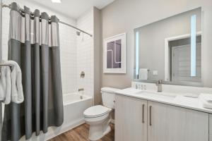 a bathroom with a toilet and a tub and a sink at AVE Tampa Riverwalk in Tampa +23 photos
