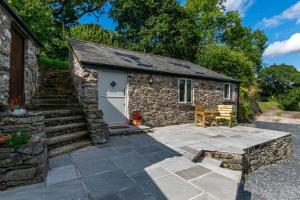 a stone cottage with a patio and stairs at 1 Bed in Abergele oc-bow134 in Llanfair Talhaiarn