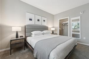 a white bedroom with a large bed and two lamps at AVE Tampa Riverwalk in Tampa