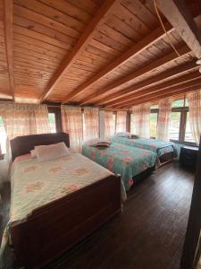 a bedroom with two beds and a wooden ceiling at Europa Ecotours in Jardin