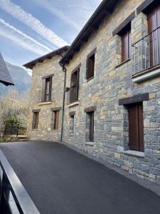 a stone building with a road in front of it at Chalet Hoz de Jaca in Hoz de Jaca