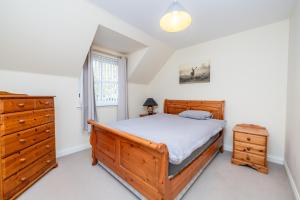 a bedroom with a bed and a dresser and a window at Abbey View in Old Deer