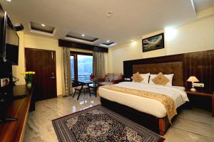 a bedroom with a large bed and a living room at The Summerlead, Shimla in Shimla
