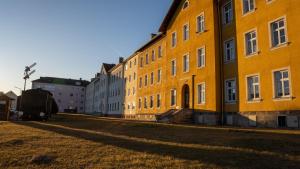a large yellow building sitting on the side of a street at Tom s Apartment II in Knittelfeld