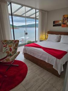 a bedroom with a bed and a chair and a window at Hotel Boutique Coração Aberto in Capitólio +139 photos