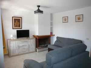 a living room with a couch and a tv at Inocencia in Alcossebre