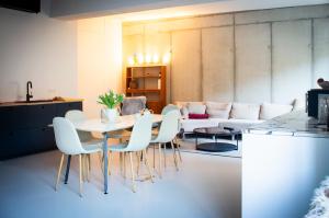 a living room with a table and chairs and a couch at Spreeblick Studio Design-Loft mit Terrasse & Parkplatz in Berlin