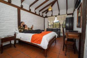 a man and a man laying on a bed with a baby at Hostal Inti Luna in Baños