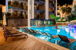 a swimming pool with lounge chairs in a hotel at SA Apartments! Cleopatra Beach Duplex with Terrace in Alanya