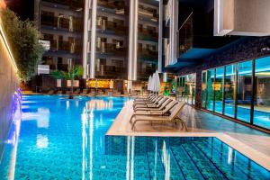 a swimming pool with lounge chairs and a hotel at SA Apartments! Cleopatra Beach Duplex with Terrace in Alanya