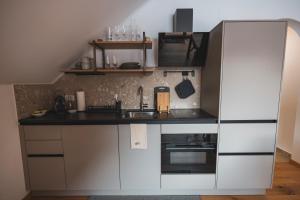 a small kitchen with white cabinets and a sink at Der Sagbauer in Donnersbachwald
